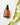 Eine braune Glasflasche Farm Loves Face Ceramide + Bio-Chicoree Barriere Hydro Creme steht auf einer weißen Oberfläche neben grünen Blättern und weißen Blütenblättern und unterstützt deine Hautbarriere.