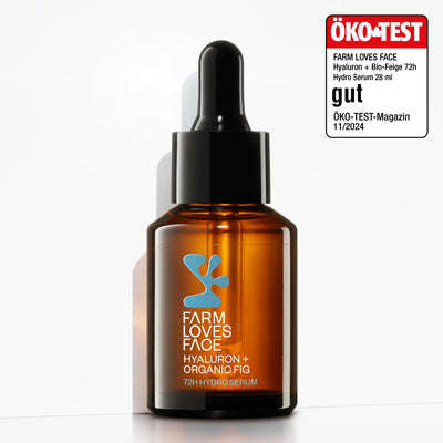 Eine braune Tropfflasche aus Glas mit der Aufschrift „Farm Loves Face Hyaluron + Bio-Feige 72h Hydro Serum“ steht auf einer weißen Fläche und präsentiert dieses Feuchtigkeitsserum für Tiefenhydratation. In der oberen rechten Ecke befindet sich ein ÖKO-TEST-Siegel.