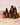 Ein Set aus Farm Loves Face Abendroutine Sparset-Hautpflegeflaschen und -Tropfern, einschließlich eines Peeling-Serums, präsentiert auf einer Holzoberfläche mit gefalteten Handtüchern, einer Haarspange und einem rosa gefliesten Hintergrund.